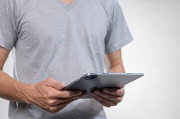 Person Holding Tablet Computer in Casual Grey T-Shirt