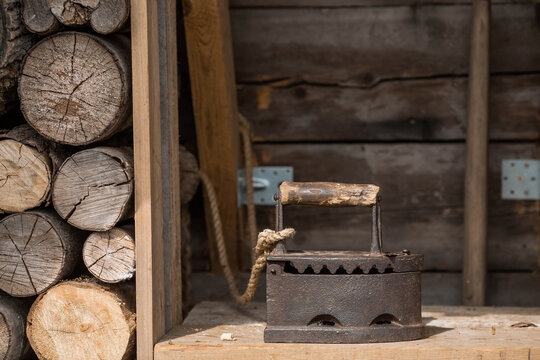 An old cast-iron iron heated over hot coals. Retro and vintage.