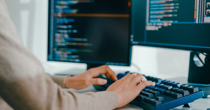 Closeup young adult Asia female freelance type write prompt AI bot IT app smart program nomad, video game, terminal with coding language, user interface, designer, big data center on desktop computer.