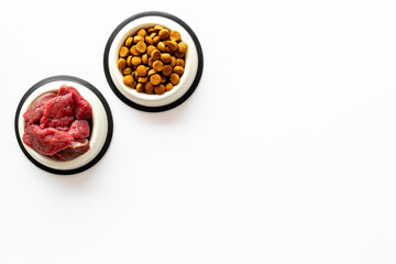Various pet food in feeding bowls. Natural and dry food for choice. Top view