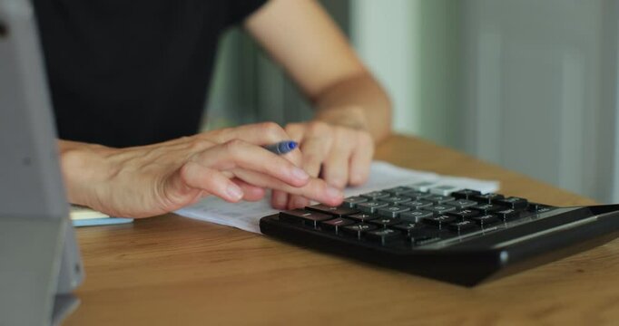 Close up view of man accountant working using calculator. Analyze company charges calculate expenses concept.