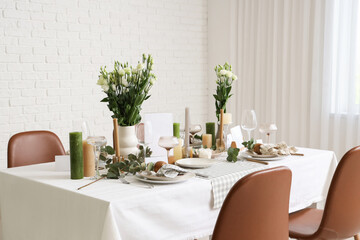 Beautiful table setting with eustoma flowers and eucalyptus for wedding celebration in room