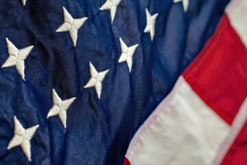 A close up view of the american flag with white stars on a blue field and red and white stripes visible