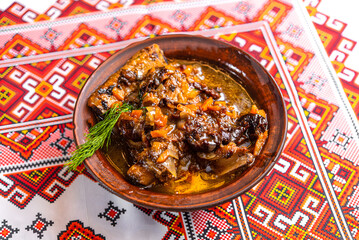 Ukrainian stewed pork with vegetables on an embroidered tablecloth