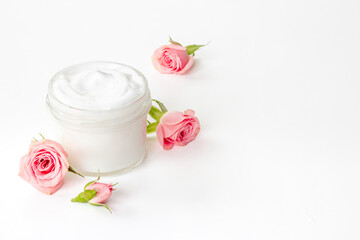Closeup of pink roses essence skin care cream with flowers and petals
