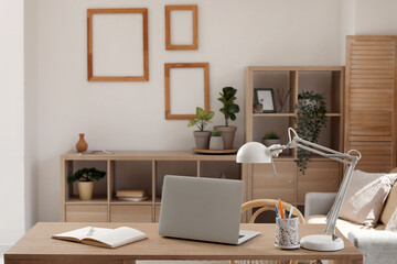 Stylish room with folding screen, workplace, lamp and modern laptop
