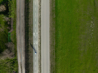 Aerial top down photo of a single cyclist exercising on a summer day.