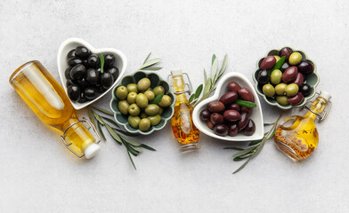 Black, green and kalamata olives with olive oil and olive branches creating a mediterranean...