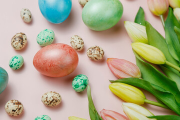 Easter eggsin basket on pink background with tulips.
