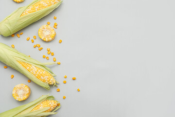Fresh corn cobs with seeds on grey background