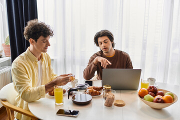 At home together: a loving gay couple enjoying breakfast in their modern apartment