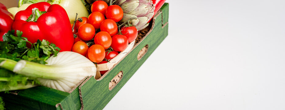 Farm grown organic vegetables in delivery box on white background with copy space