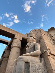 Colossus of seated Ramesses II at Temple of Luxor during sunset, Egypt