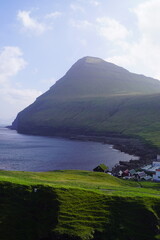 Stunning views at the charming village of Gjogv surrounded by lush green mountains in the Faroe Islands