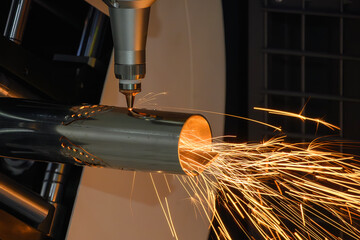 Close up scene the fiber laser cutting machine cut the stainless steel tube and sparkling light.
