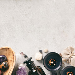 Crystal Healing Stones and Essential Oil Bottles on Gray Background