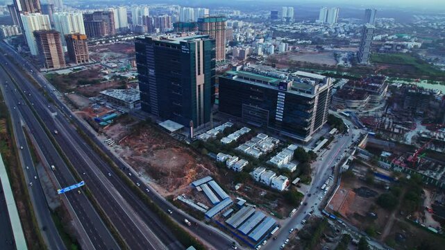 Gar infobahn buildings with hyderabad ORR and vehicles at nanakramguda, financial district, hyderabad, telangana, india. day time, moving up, tilt down, drone shot, 4k.