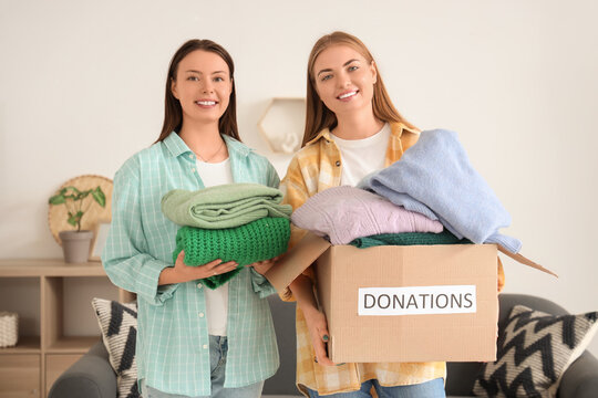 Young women with clothes for poor people at home