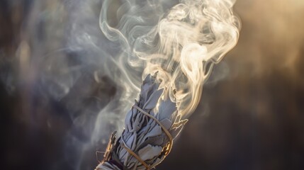 Burning sage bundle with rising smoke and sunlight at dusk