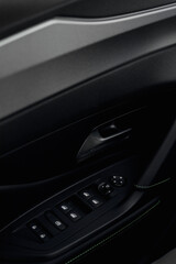 Naklejka premium Close-up of car door panel with window controls and armrest