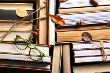 Books with autumn leaves, eyeglasses and acorns, closeup