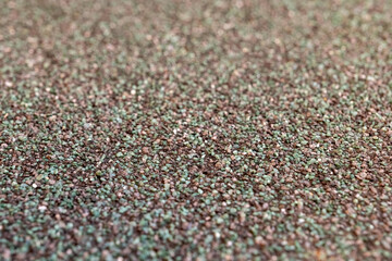 Sparkling grains of sand filling the beach shoreline under bright sunlight during the warm summer afternoon