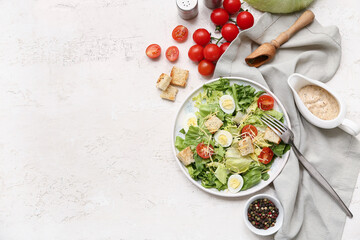 Plate with tasty Caesar salad and ingredients on white background