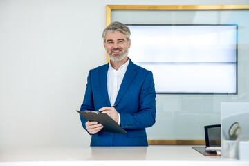 Manager in car showroom conducting online conference using professional display for dealership...