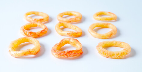 Fried onion rings ,crispy snack  tomato flavour on white background.
