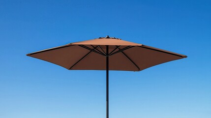 Brown beach umbrella against clear blue sky on sunny day