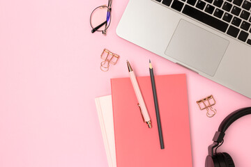 Workspace with laptop and office supplies on a pink background. Business layout with place for text.