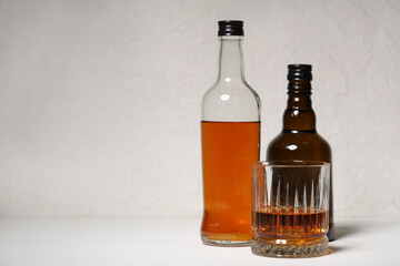 Glass and bottles of rum on white background