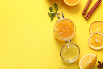 Jar of tasty orange jam on yellow background