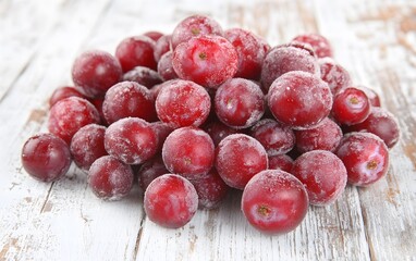 Frozen Red Plums Pile on Rustic White Wood Background