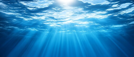 Sunlight streams underwater illuminating the depths of the ocean blue