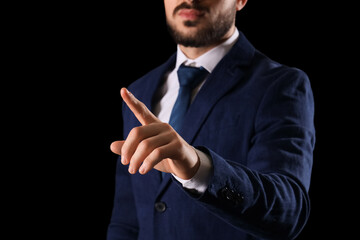 Businessman using virtual screen on dark background, closeup. Goal concept