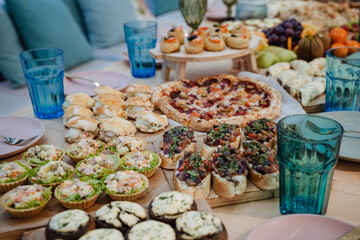A beautifully arranged table is adorned with a diverse collection of delicious food items and an assortment of refreshing drinks, creating an inviting atmosphere for everyone present