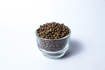 Organic Black Peas in a Glass Bowl isolated on a white background. Black-eyed peas also called parched peas or dapple peas or Kala Vatana Desi Black Peas.