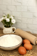 Baking products - flour, eggs. Flour and eggs on the table close-up