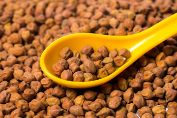Closeup shot of Organic Brown Chickpeas in a Spoon. Black chickpeas, also known as kala chana, Bengal gram,Egyptian pea.