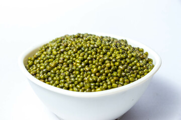 Green Moong Dal beans in a White Bowl Isolated on a white background. The mung bean or green gram (Vigna radiata).