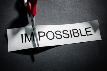 Scissors cutting the word impossible to make possible concept for self belief, positive attitude...