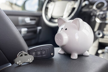 Piggy bank money box and car key inside car, vehicle purchase, insurance or driving and motoring cost