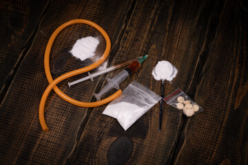 Syringe with drugs dose and medical tourniquet on black background. Narcotic substances in spoon....