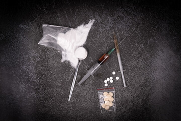 Syringe with drugs dose on black background. Narcotic substances in spoon. powder in plastic bag....