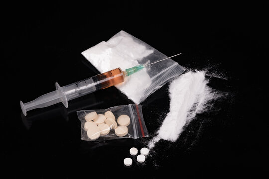 Syringe with drugs dose on black background. Narcotic substances in spoon. powder in plastic bag. Drugs concept on dark place. Heroin narcotic crime. Danger addict problem criminal