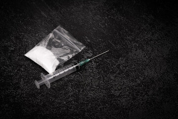 Syringe with drugs dose on black background. powder in plastic bag. Drugs concept on dark place. addiction and bad habits. Heroin narcotic crime. Danger addict problem criminal