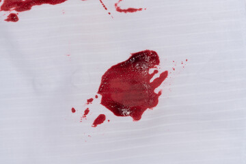Drops of blood stains on white fabric. blood splatters on clothes. red dripping blood spatters