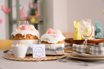 Greeting card with text HAPPY EASTER on table served for Easter celebration. Closeup