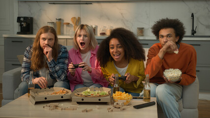 Multiracial friends multiethnic people at home weekend fun Caucasian woman lost failure console game African girl female win video gaming celebrate men guys males drinking beer eat popcorn friendship